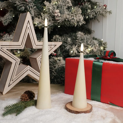 Two white cone-shaped candles with lit wicks on a dark surface with a gray background.