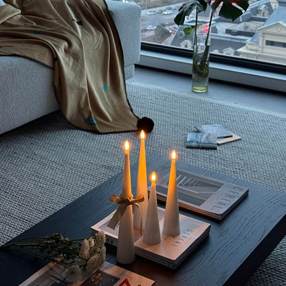 Candle holder with lit candles on a coffee table in a living room.