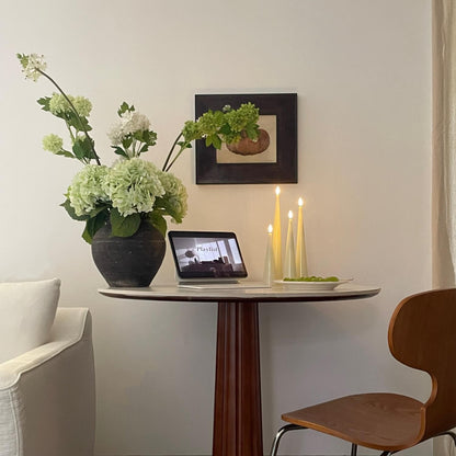 Small dining area with a table, chair, laptop, and decorative items.