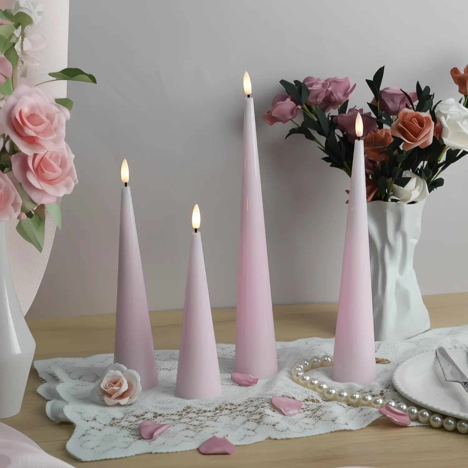 Set of three pink candles on a surface with decorative items in the background