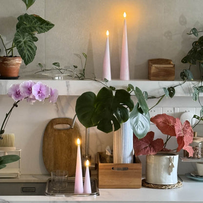 Decorative setup with candles, plants, and a cutting board on a shelf.