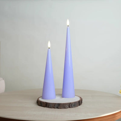 Two purple cone-shaped candles on a wooden base with a neutral background