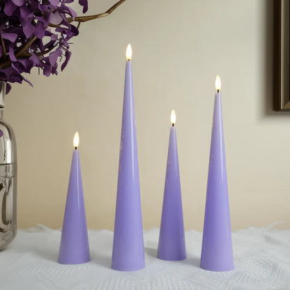 Four purple cone-shaped candles with lit wicks on a textured surface, with a vase of purple flowers in the background.