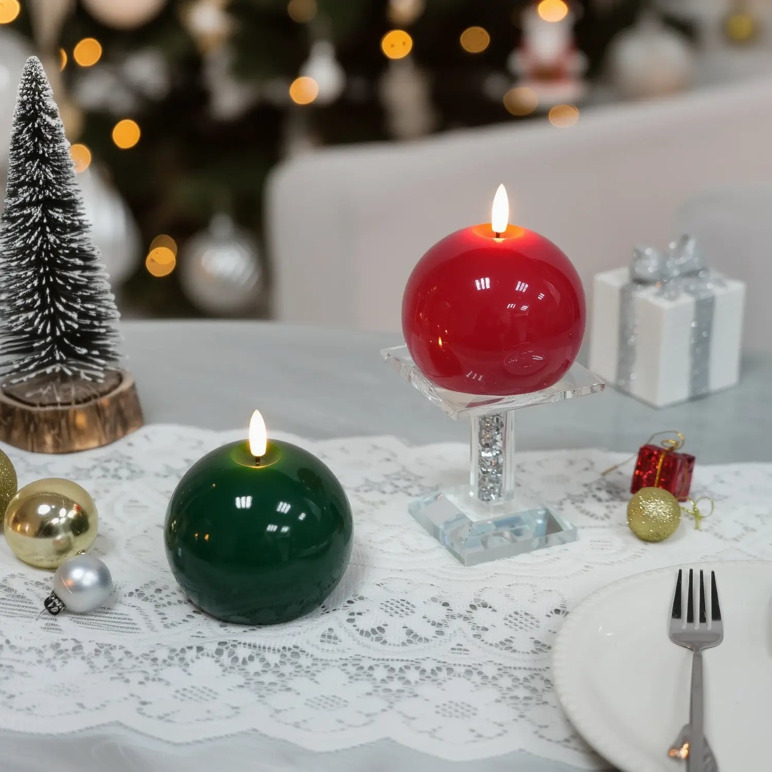 Red spherical candle on a wooden base with a Christmas tree and gift in the background#color_shiny-red