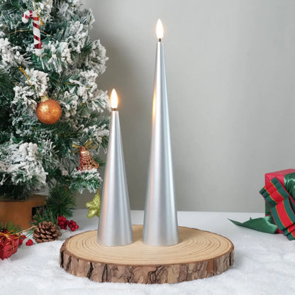 Two silver candles on a wooden base with a Christmas tree in the background