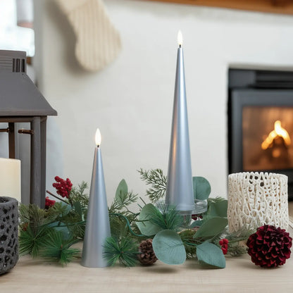 Decorative setup with silver candles, greenery, and red berries on a table.