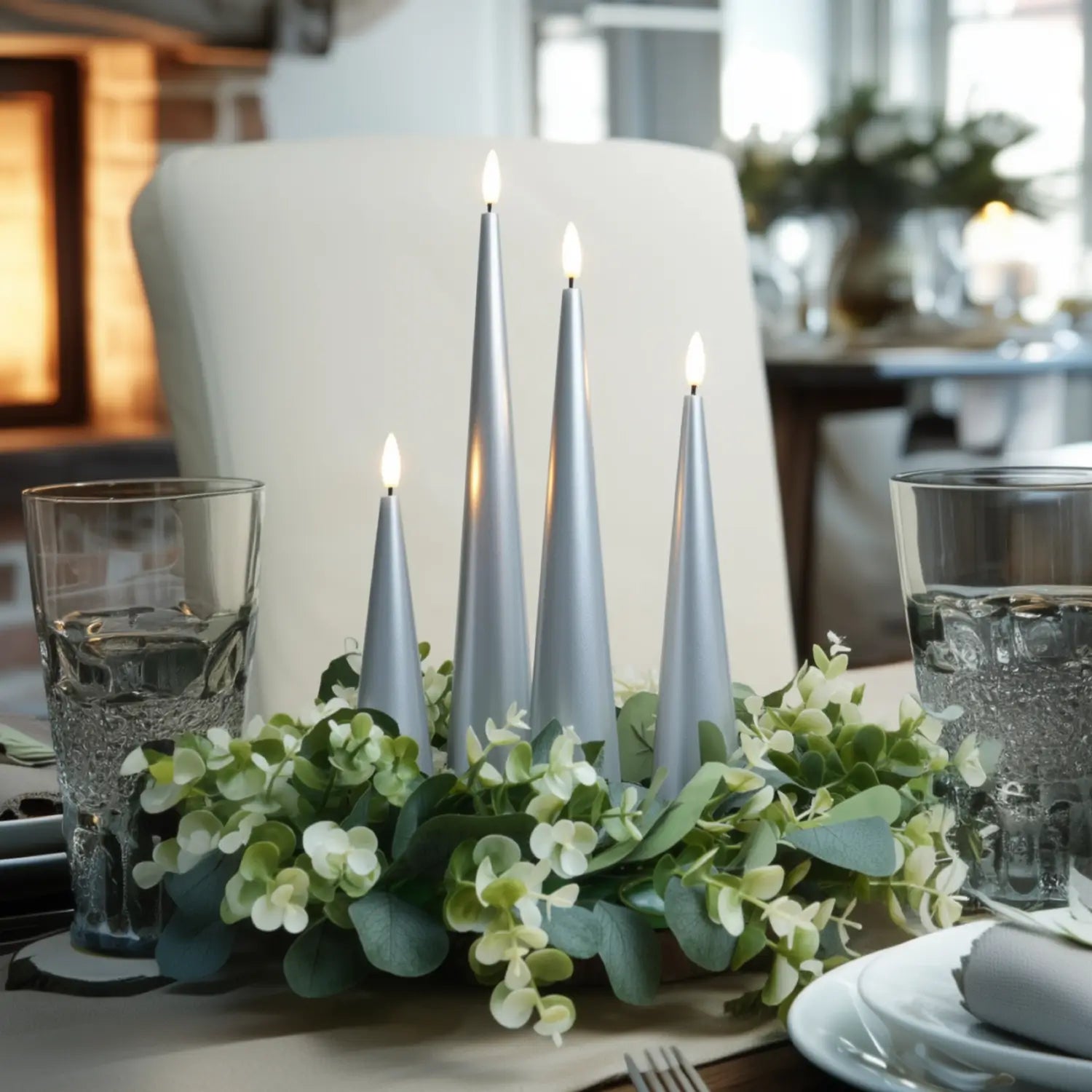 Decorative table setting with candles and greenery on a dining table.
