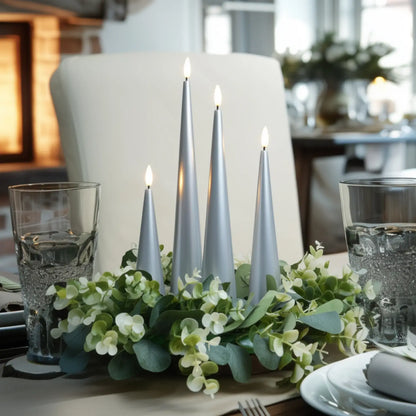 Decorative table setting with candles and greenery on a dining table.