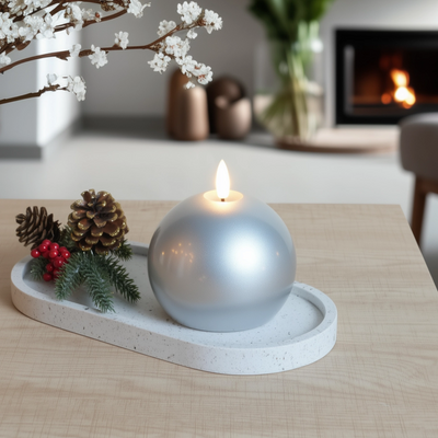 Decorative candle on a stone tray with festive elements in a cozy living room.