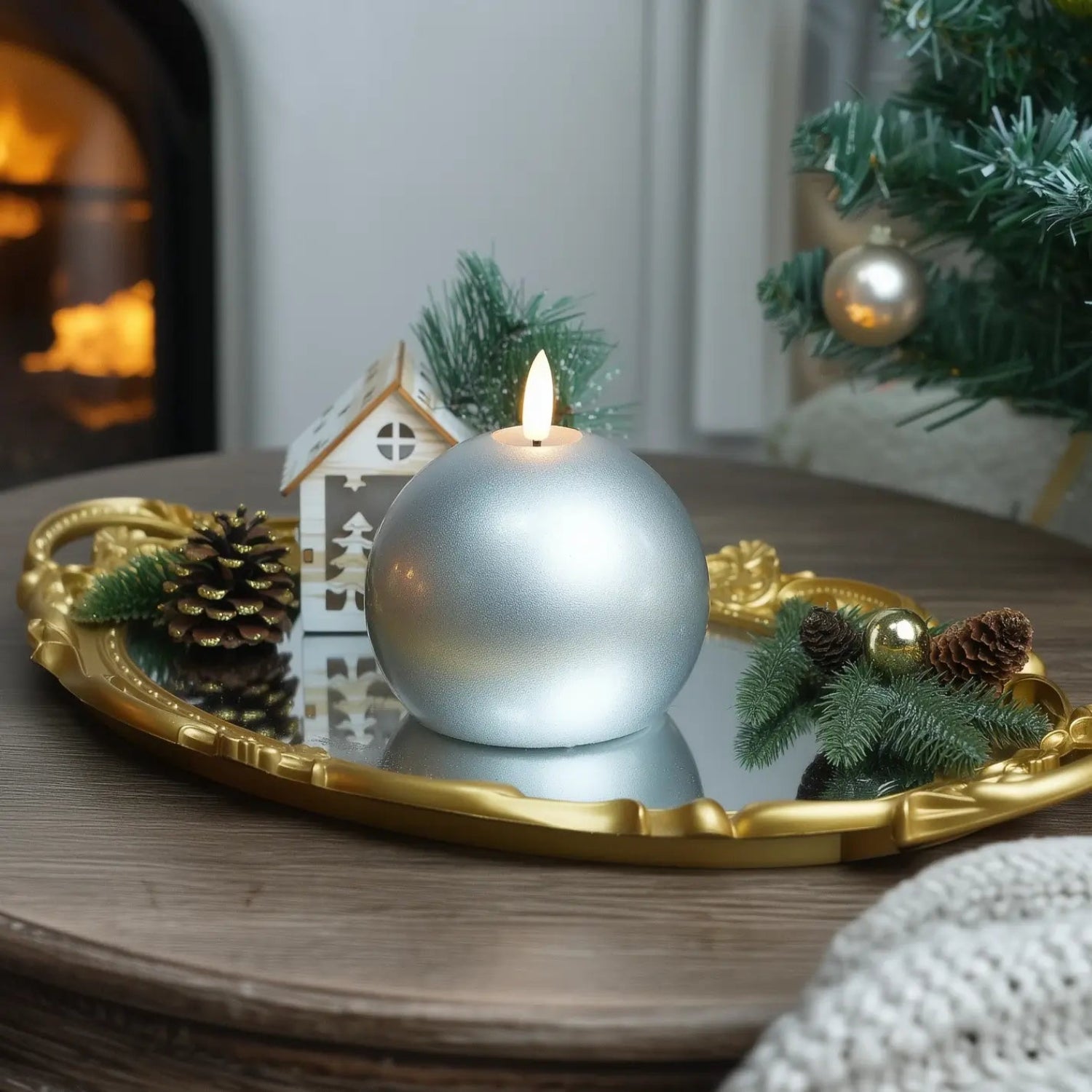 Decorative candle on a stone tray with festive elements in a cozy living room.