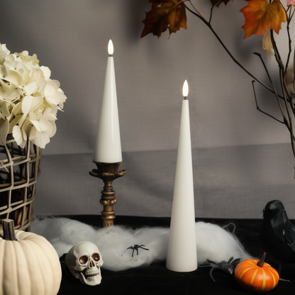 Decorative setup with white candles, pumpkins, and a skull on a dark surface.