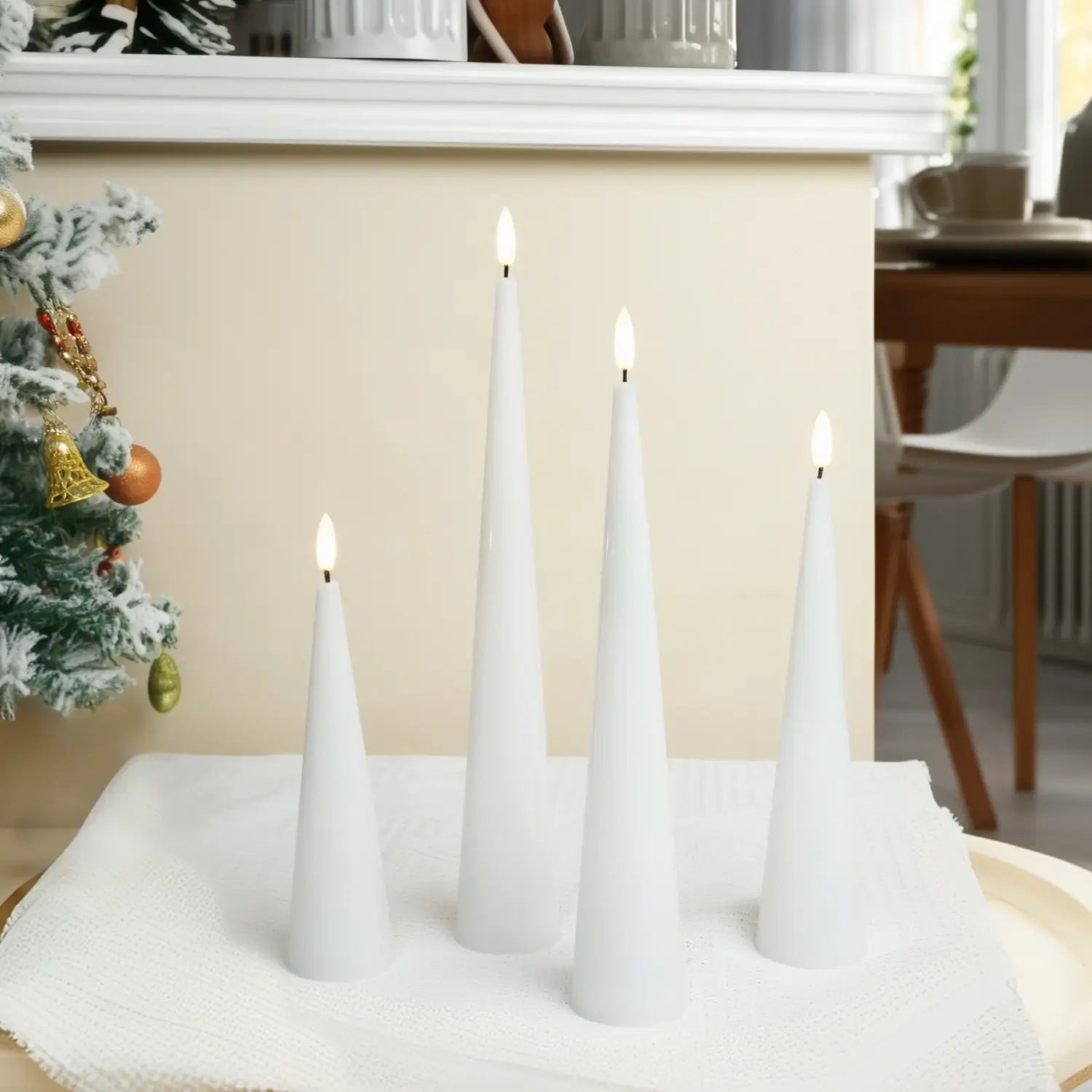 White cone-shaped candles on a table with a Christmas tree in the background