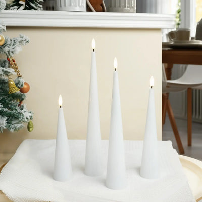 White cone-shaped candles on a table with a Christmas tree in the background