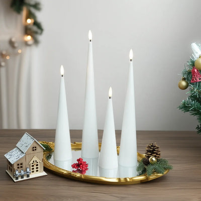 Decorative setup with white candles, pumpkins, and a skull on a neutral background
