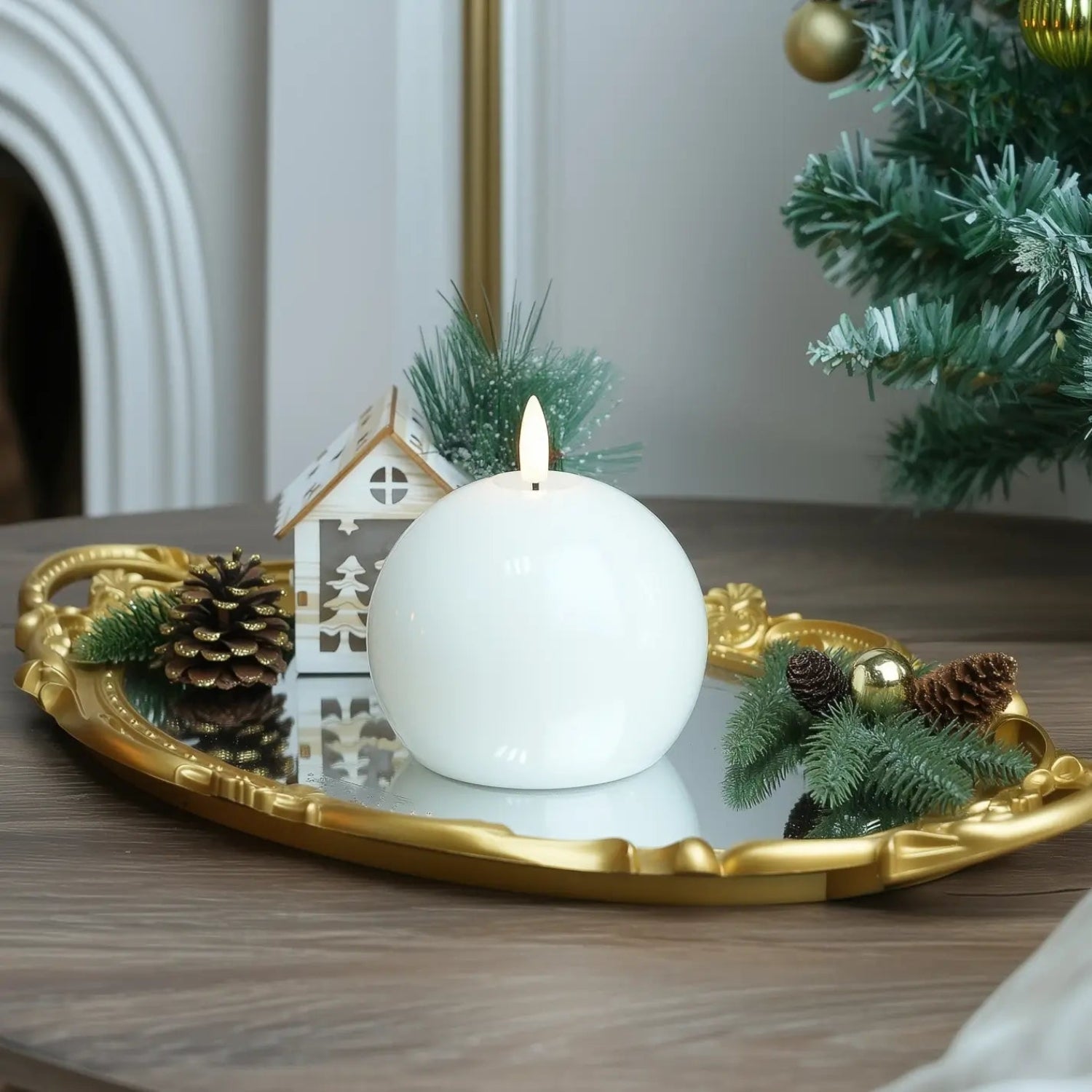 White candle on a wooden base surrounded by greenery and pine cones.