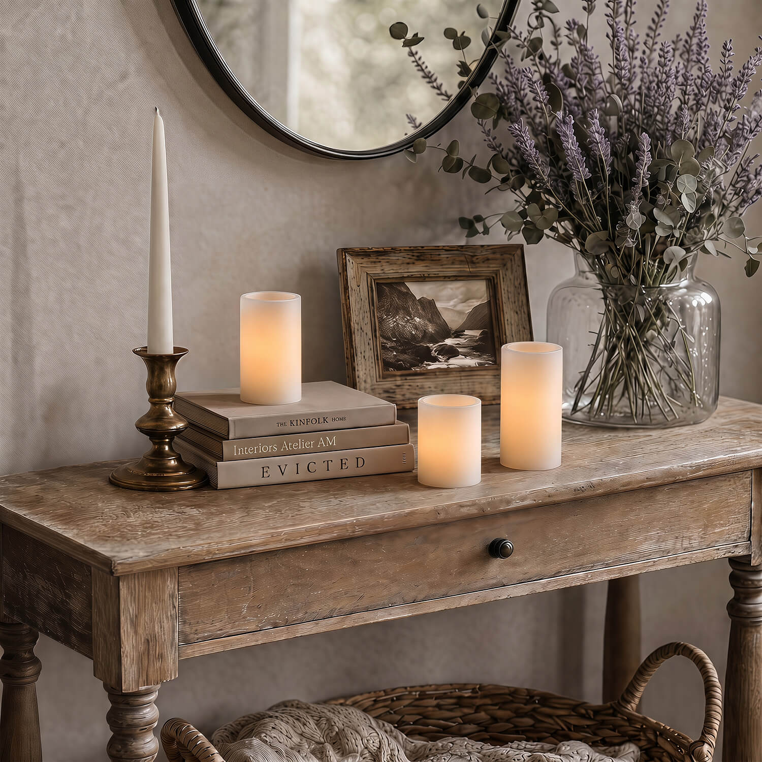Decorative table with candles, books, and a vase of flowers in a home setting.